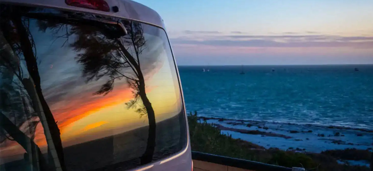 Campervan window reflecting the sunset