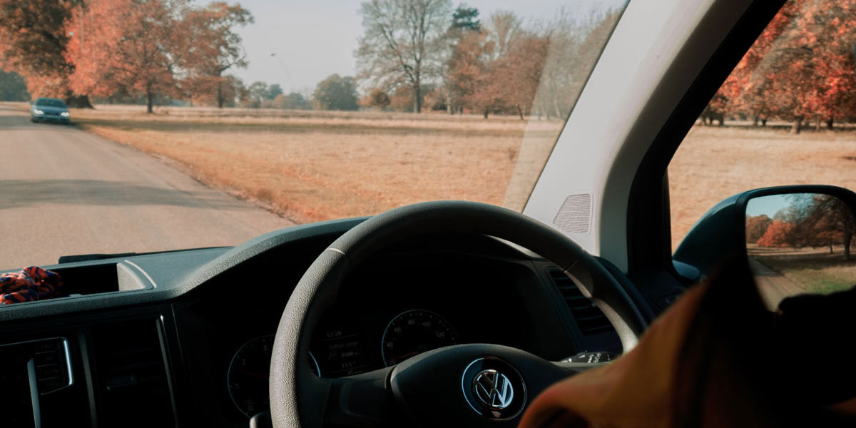 Looking through the windscreen of a VW camper driving on the road