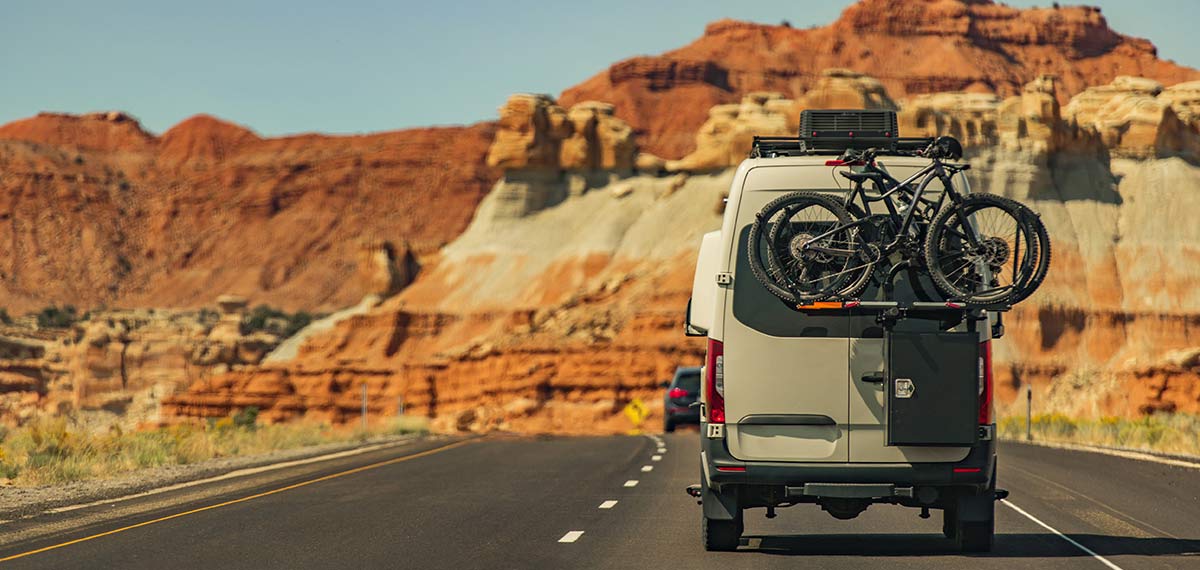 Campervan-on-a-scneic-route Campervan driving along a scenic route with bikes on the back