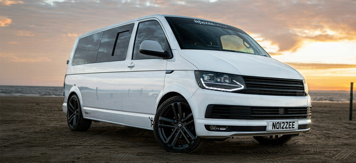 White VW Campervan on a beach at sunset