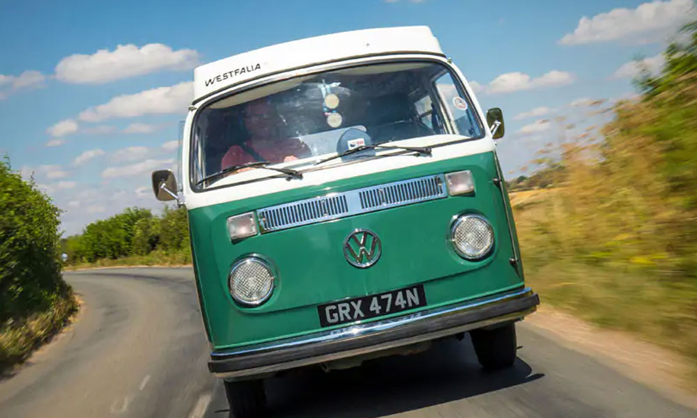JKI25-Classic-Campervan-Insurance-Header-1 Shaun from Just Kampers driving his green VW T2 Bay
