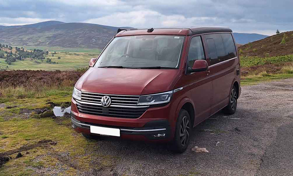 JKI25-VW-California-Campervan-Insurance-Header-1 A Volkswagen California campervan parked up with a scenic view