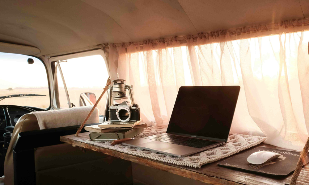 Campervan-Personal-Effects-Cover-Header-Image-for-Just-Kampers-Insurance The interior of a classic campervan with a camera and laptop on a table, which are a couple of things things protected by Personal Effects Cover from Just Kampers Insurance