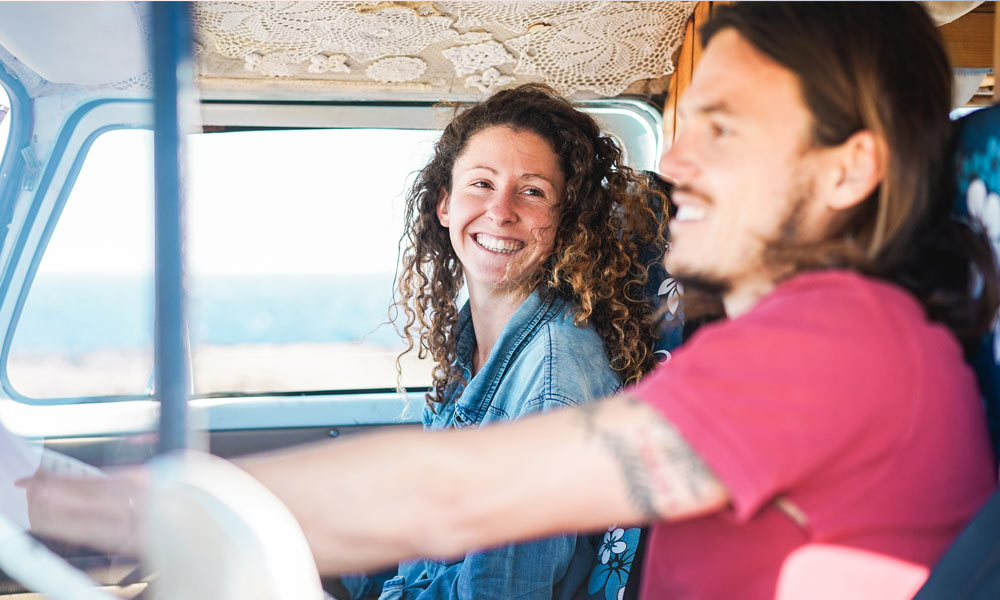 JKI25-Standard-Benefits-Image-Header-1 A couple driving their campervan and smiling