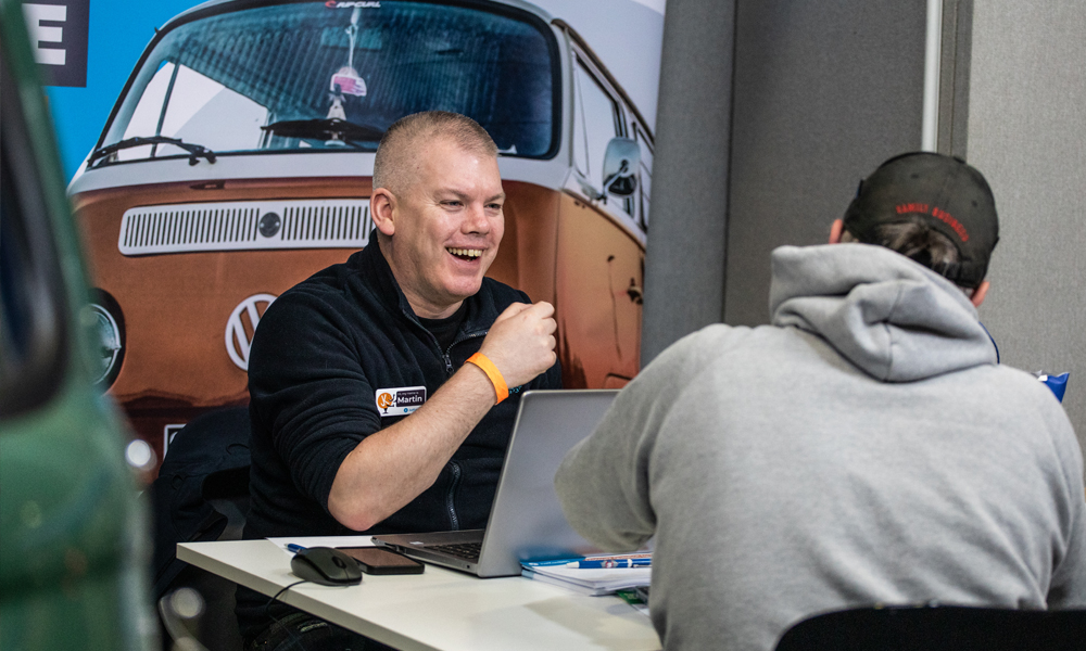 Quick-Switch-Header-Image-for-Just-Kampers-Insurance Martin from the Just Kampers Insurance Team speaking with a customer at a classic Volkswagen show