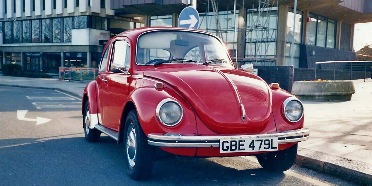 Pros-and-cons-of-driving-classic-car-every-day-1 Red VW Beetle parked on an urban road