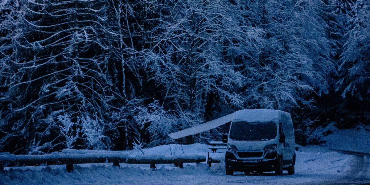 Campervan by the snowy trees