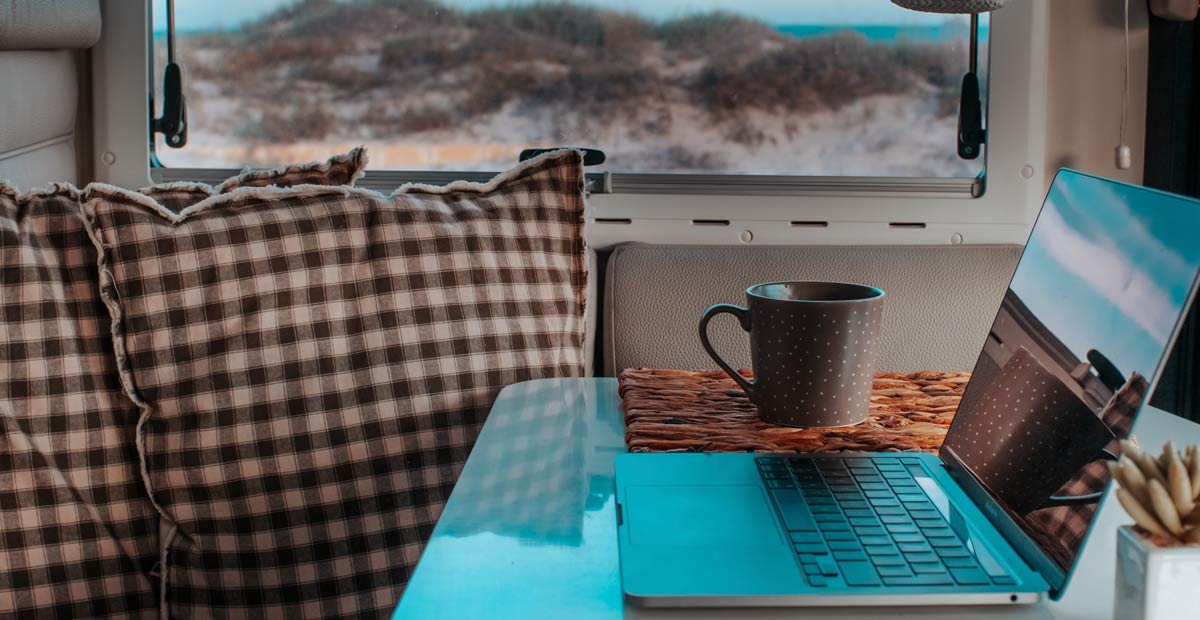 Laptop and coffee cup on a table inside a motorhome