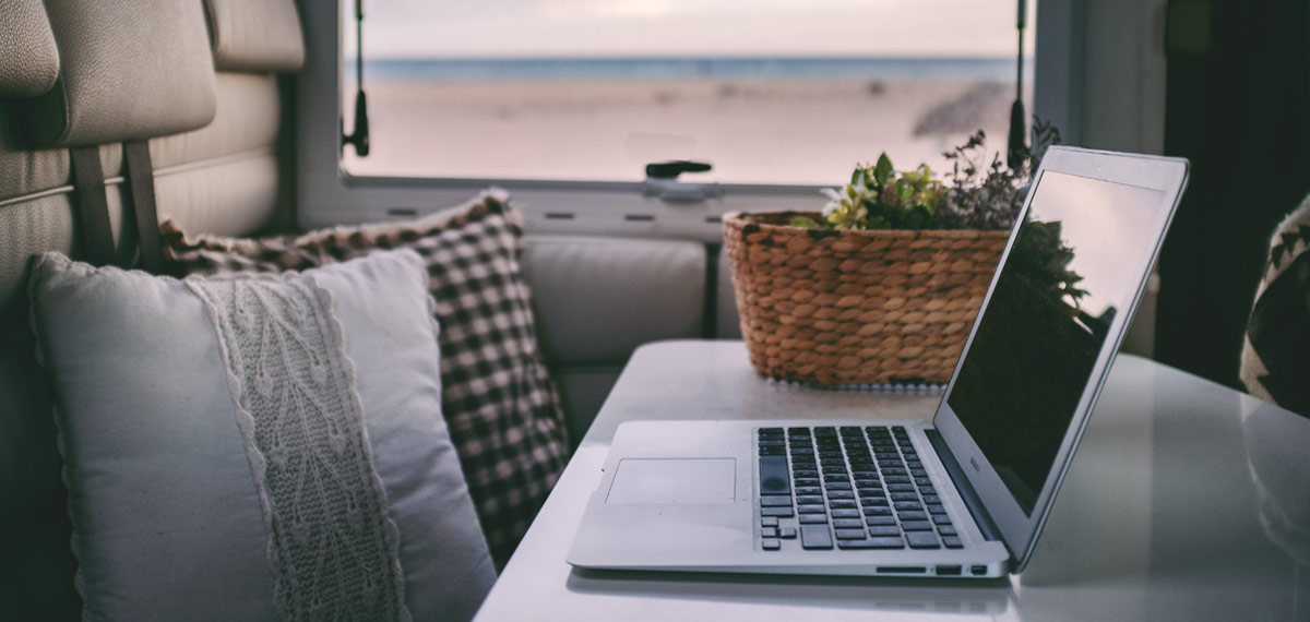 Laptop on a table inside a campervan, by the window