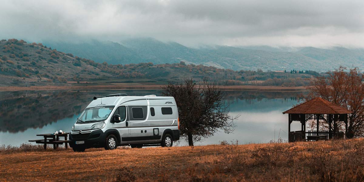 Campervan parked beside a scenic lake