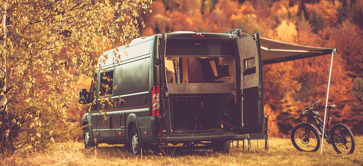 Converted campervan by the autumnal trees