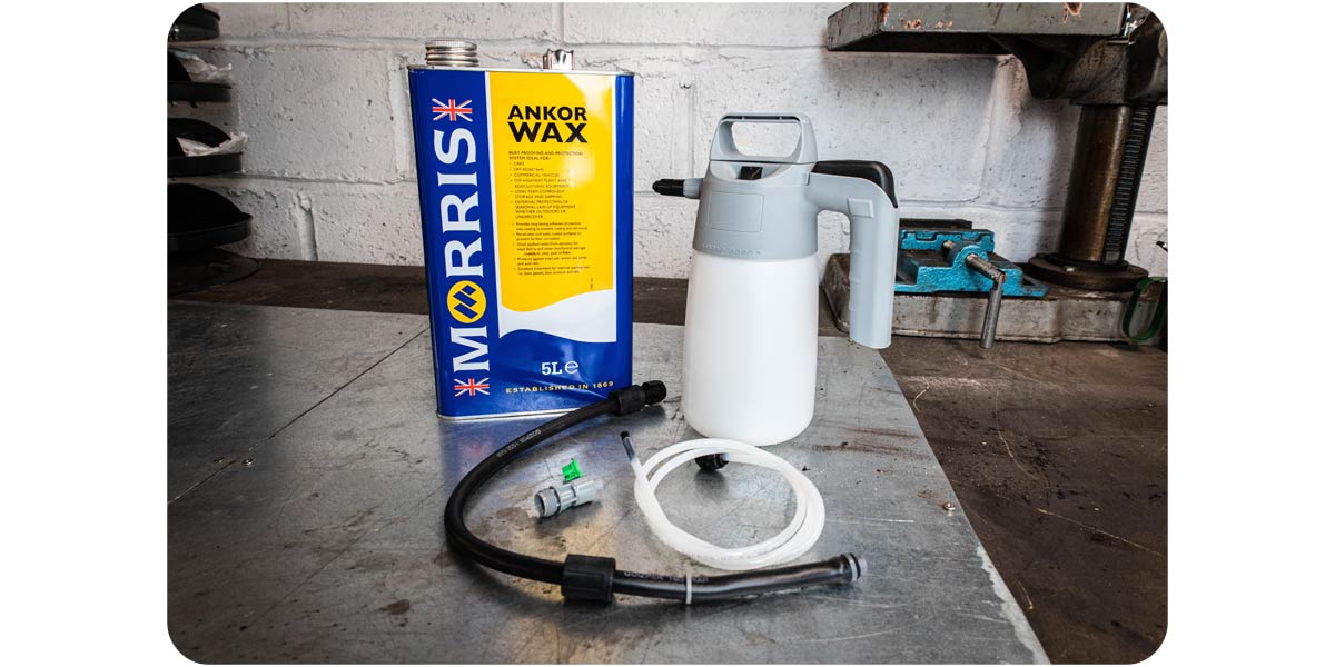 A weatherproofing bundle kit laid out on a workbench in a garage, including a can of Ankor Wax and an applicator