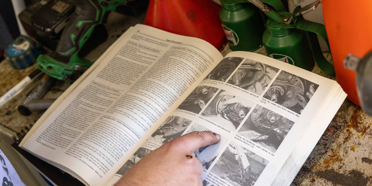 Lewis from our sister company, Just Kampers, using a workshop manual while working on his classic VW Beetle