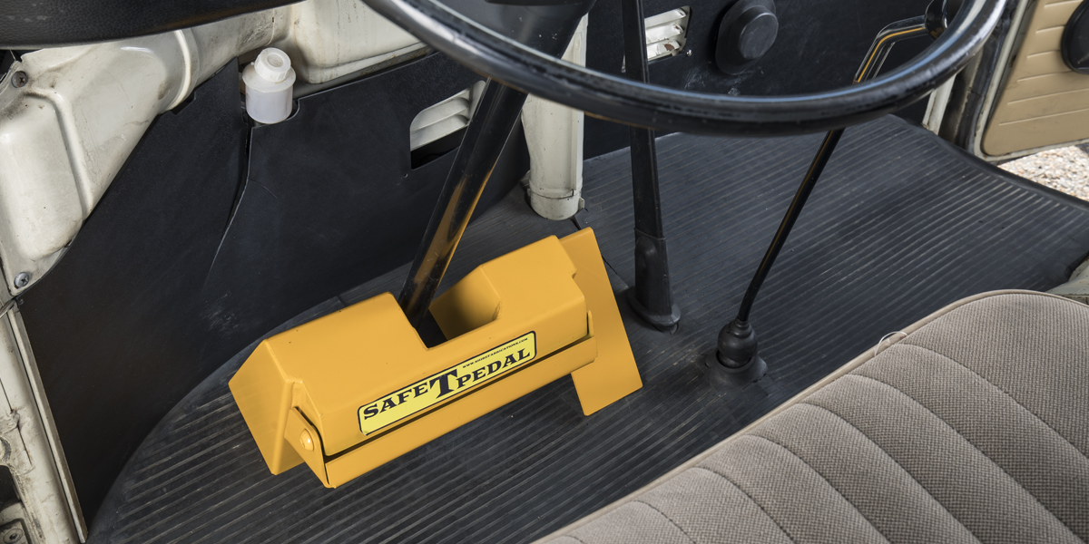 A bright yellow Safe-T Pedal fitted to a classic VW T2 Bay, showing the way in which is blocks off the pedals and prevents them being accessed or used