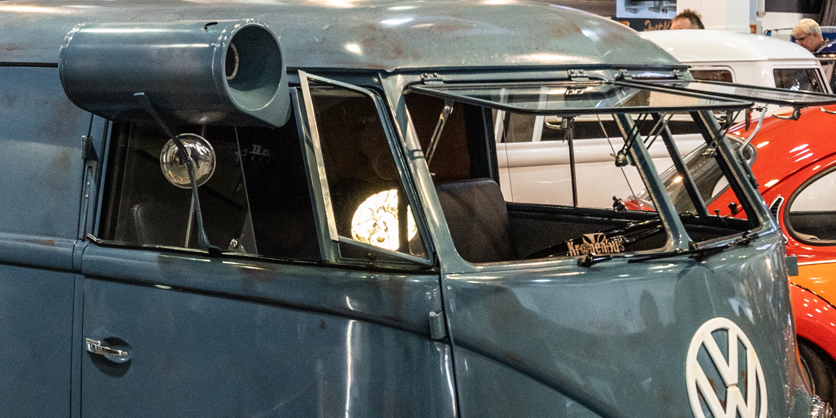 A VW T2 Splitscreen with a colour-matched swamp cooler attached the the cab window