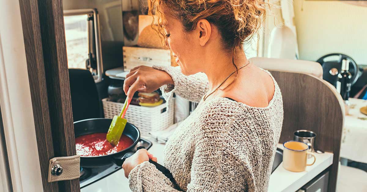 Woman cooking in a campervan