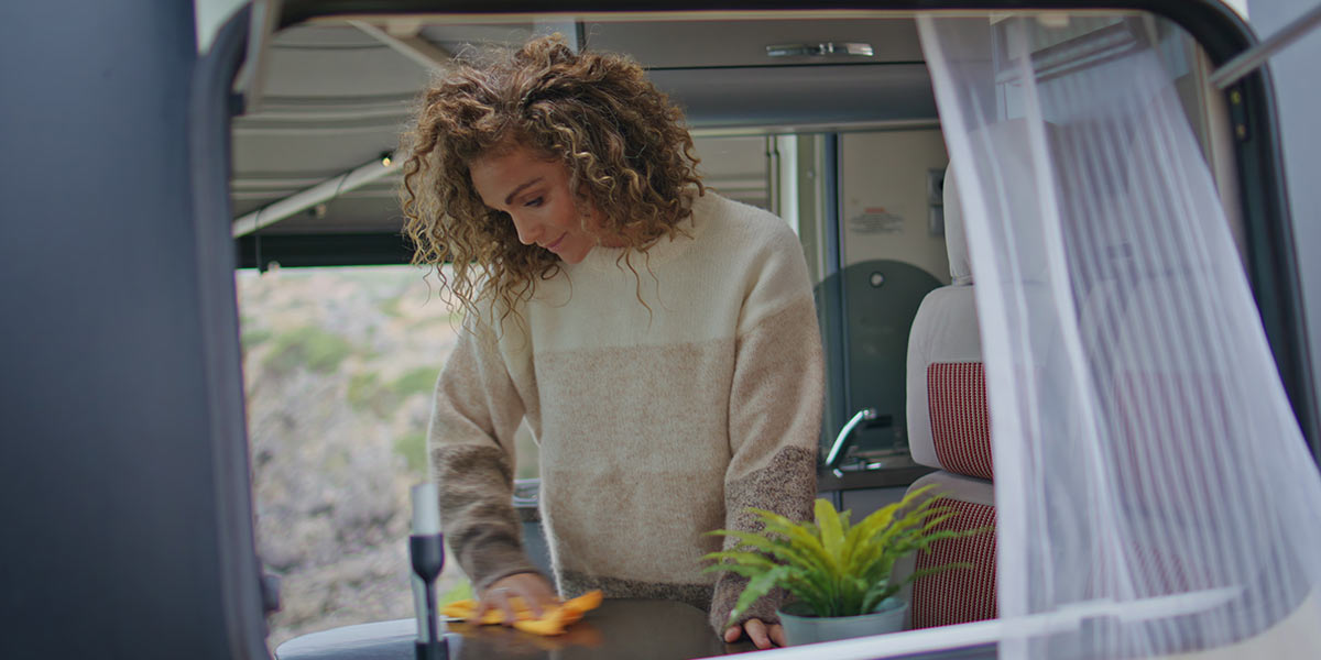 A woman drying the inside of a campervan