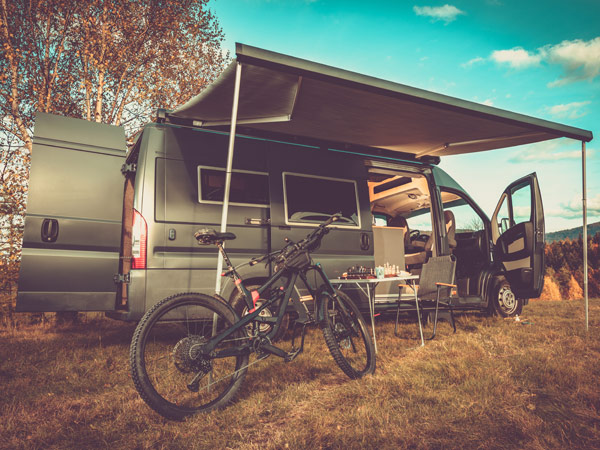 Converted campervan with awning and a bike