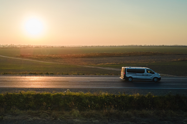 Van driving through the countryside at sunset