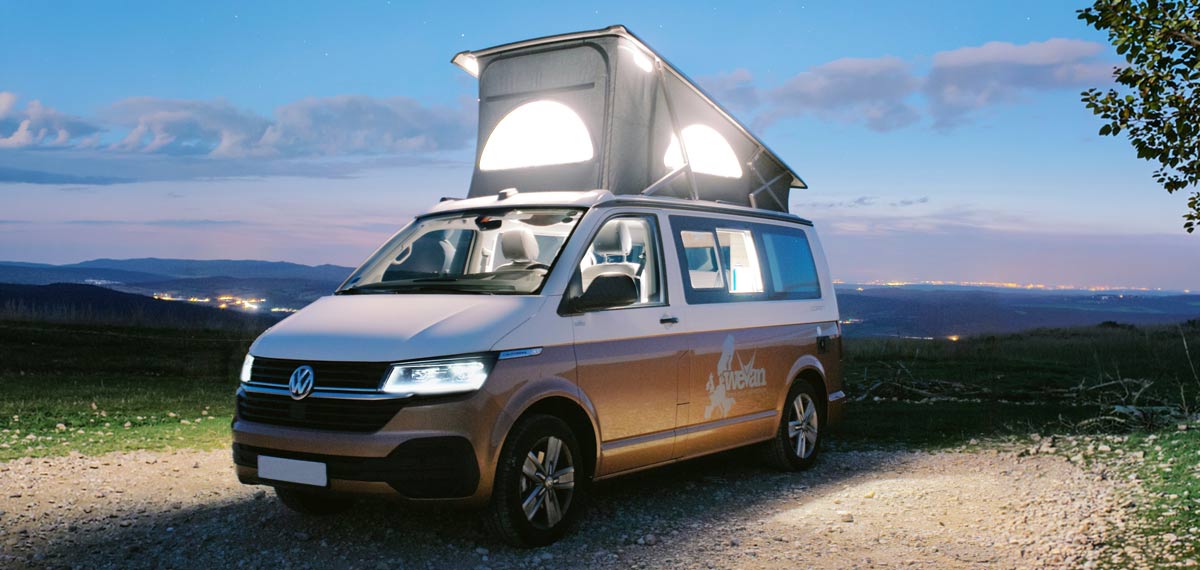 VW Camper at night with the pop-top roof elevated
