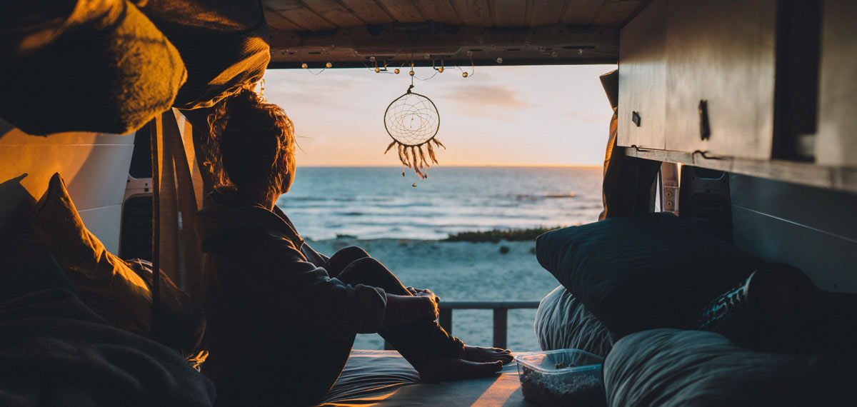 Woman looking at the ocean from a camper
